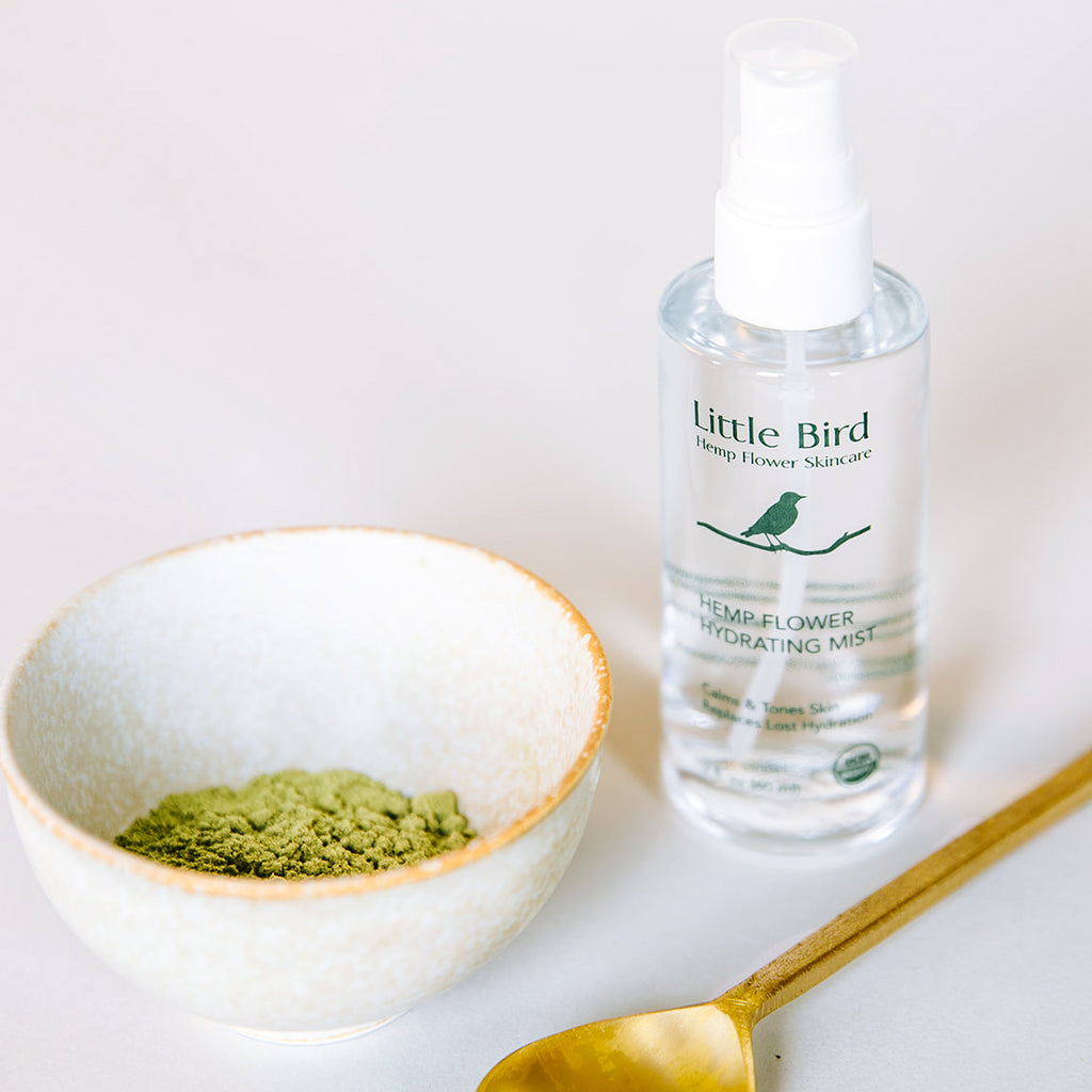 Hemp Flower Hydrating Mist  clear bottle with spoon and bowl containing powdered green hemp flower